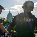 U.S. Capitol Police secure an intersection near the Capitol as activists stop traffic and call for the ouster of President Donald Trump's National Guard deployment in Washington, Wednesday, Oct. 14, 2026. (AP Photo/J. Scott Applewhite)